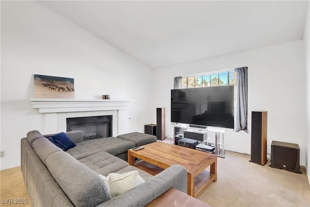 living room with light colored carpet, a tiled fireplace, and vaulted ceiling