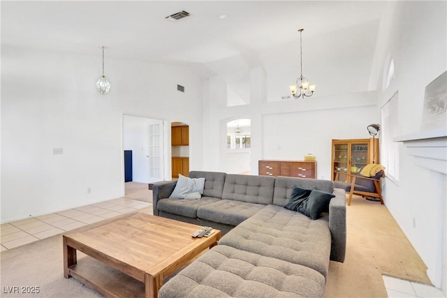 carpeted living room featuring a chandelier and high vaulted ceiling