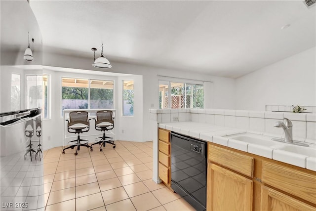 kitchen featuring decorative light fixtures, dishwasher, sink, tile counters, and light tile patterned floors