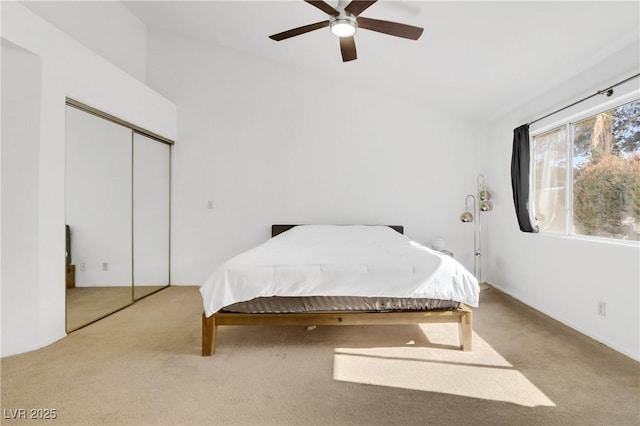 carpeted bedroom featuring ceiling fan and a closet