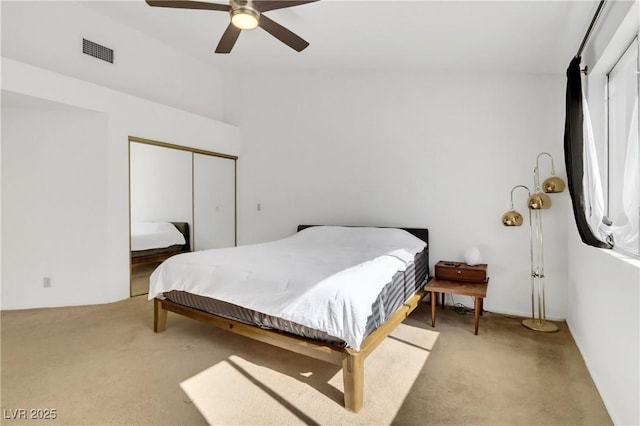 carpeted bedroom with vaulted ceiling, a closet, and ceiling fan