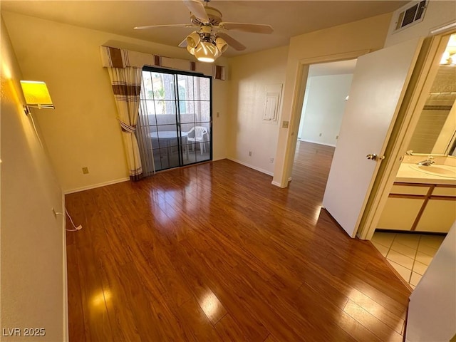 empty room with ceiling fan, sink, and hardwood / wood-style floors