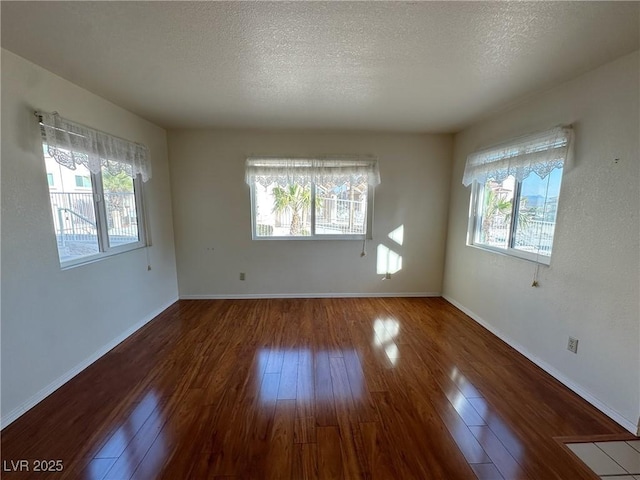 spare room featuring wood-type flooring and a textured ceiling