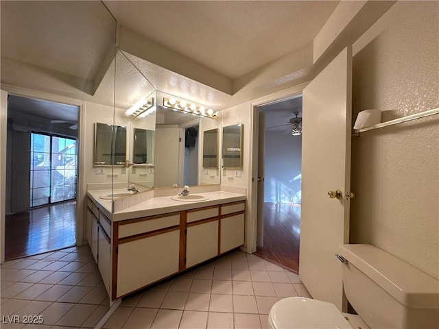 bathroom with ceiling fan, vanity, toilet, and tile patterned flooring