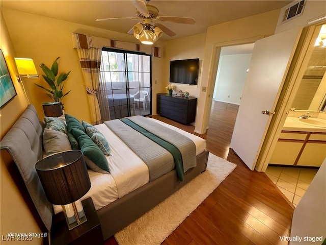 bedroom featuring sink, dark wood-type flooring, ceiling fan, and ensuite bathroom