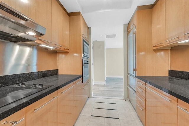 2700 Las Vegas Blvd Unit 3105, Las Vegas, NV 89109 - kitchen with extractor fan, built in appliances, light tile patterned floors, light brown cabinetry, and dark stone countertops