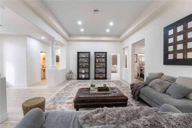 living room with decorative columns and light hardwood / wood-style floors