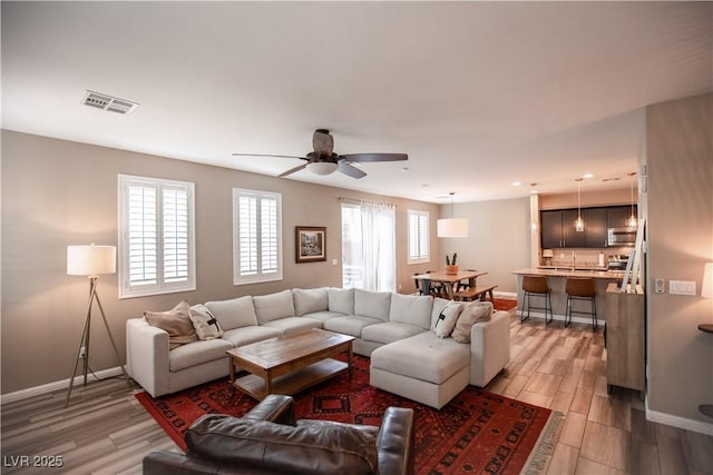 living room with hardwood / wood-style floors and ceiling fan