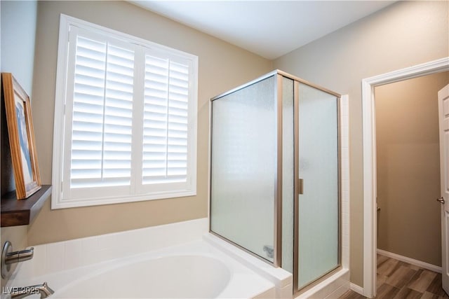 bathroom featuring hardwood / wood-style flooring, a wealth of natural light, and separate shower and tub