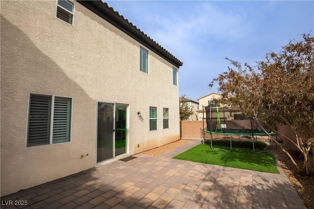 back of house with a patio and a trampoline