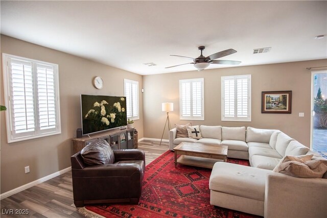 living room featuring ceiling fan, a healthy amount of sunlight, and wood-type flooring