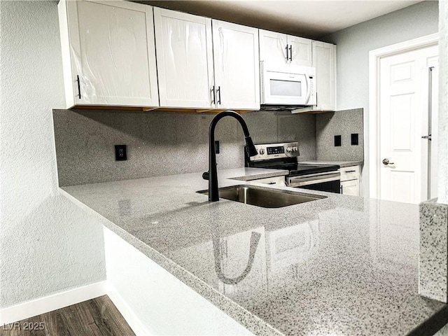 kitchen featuring tasteful backsplash, stainless steel range with electric cooktop, light stone counters, and white cabinets