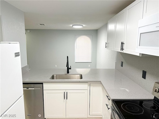 kitchen with white cabinetry, sink, light stone counters, kitchen peninsula, and stainless steel appliances