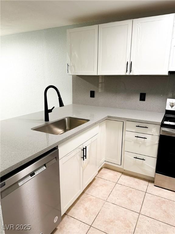 kitchen featuring white cabinetry, sink, light tile patterned floors, and appliances with stainless steel finishes