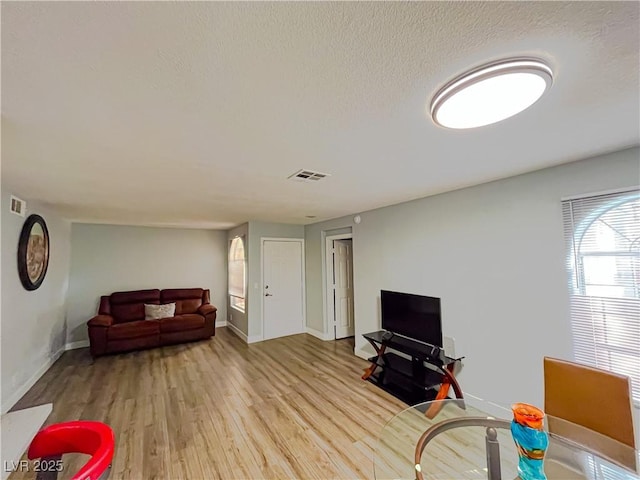 living room featuring a textured ceiling and light hardwood / wood-style floors