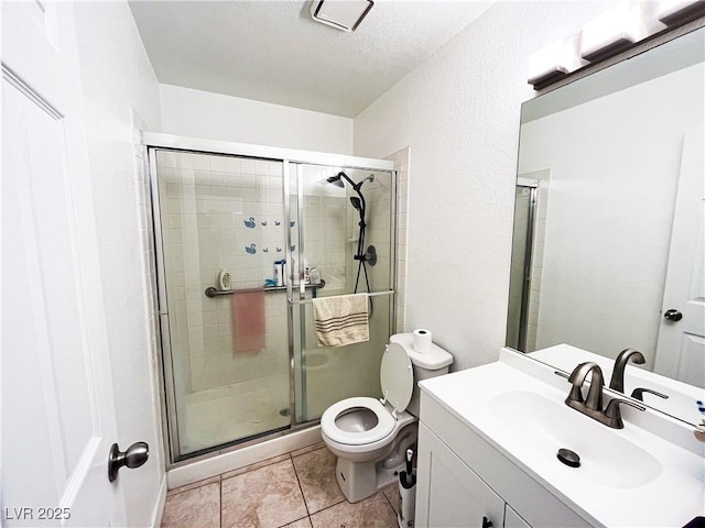 bathroom with tile patterned flooring, vanity, toilet, and walk in shower