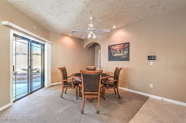 tiled dining space with ceiling fan and a textured ceiling