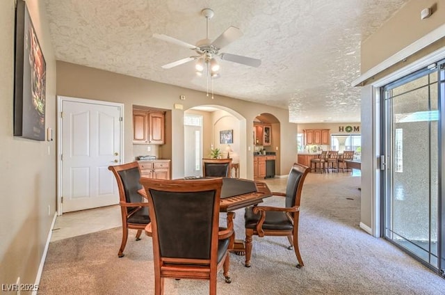 carpeted dining area featuring ceiling fan and a textured ceiling