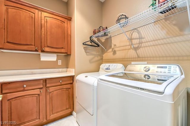 laundry room featuring washing machine and dryer and cabinets