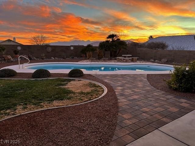 pool at dusk with a patio