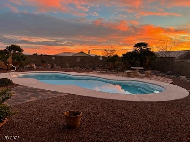 pool at dusk featuring a patio area