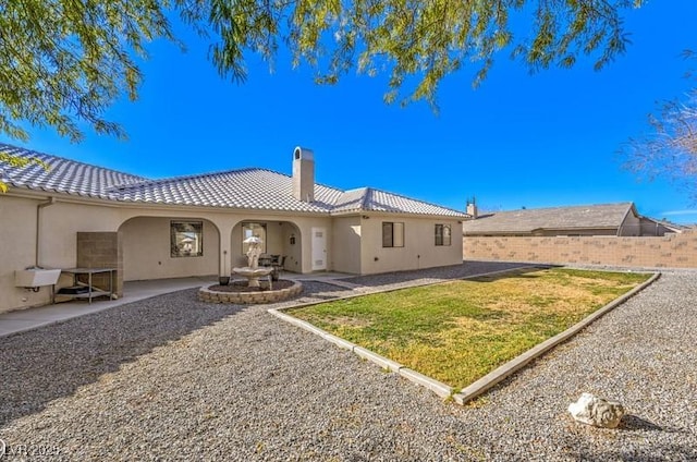 rear view of property featuring a lawn