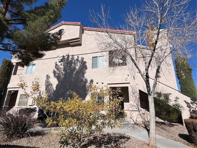 view of front of property featuring a tiled roof and stucco siding