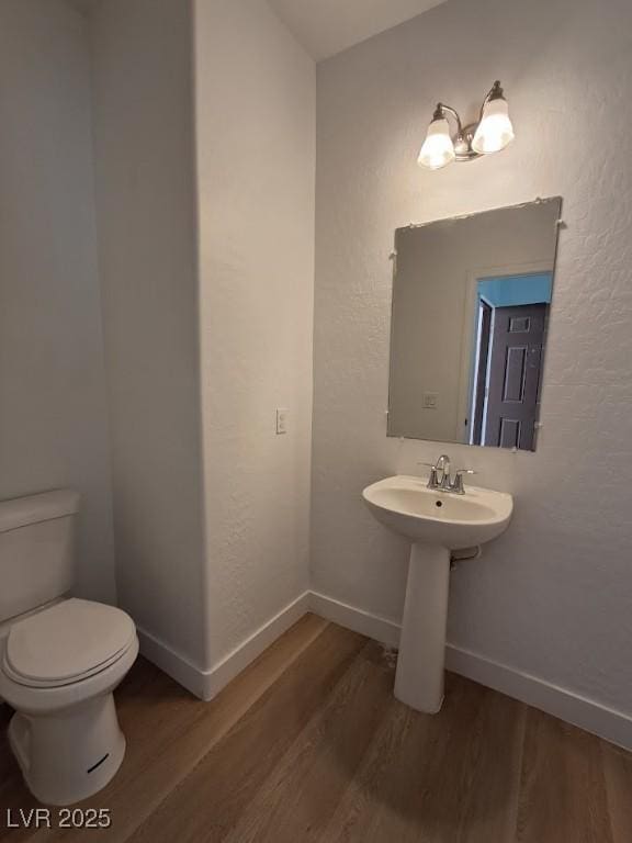 bathroom with hardwood / wood-style floors, sink, and toilet