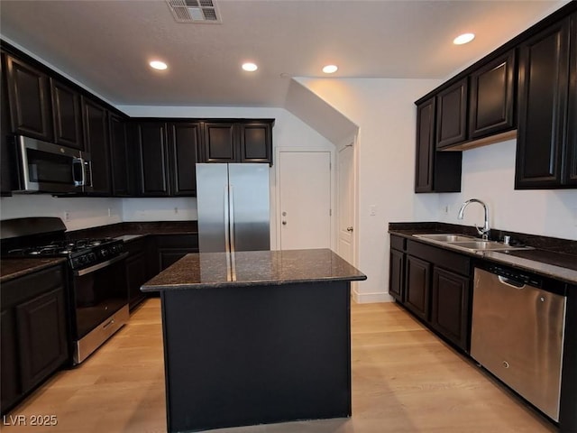 kitchen with appliances with stainless steel finishes, a center island, sink, and light wood-type flooring