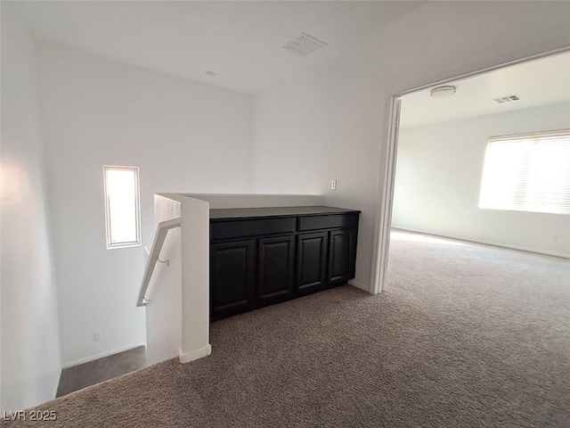 interior space featuring dark carpet and plenty of natural light