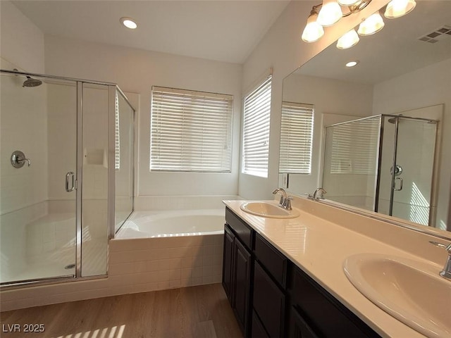 bathroom featuring independent shower and bath, wood-type flooring, and vanity