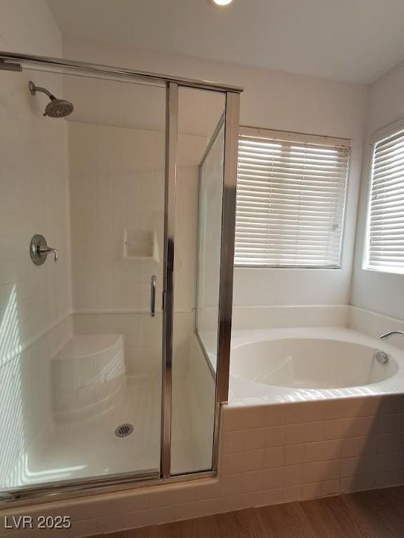 bathroom with shower with separate bathtub and hardwood / wood-style floors