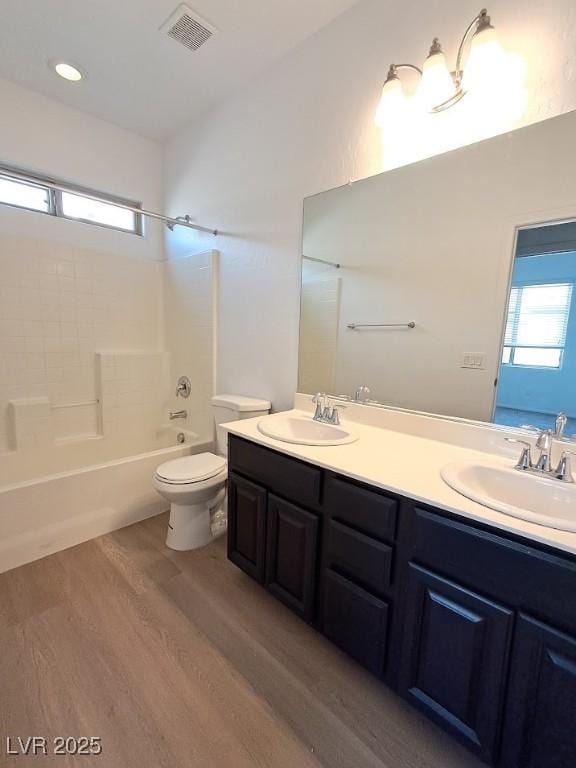 full bathroom featuring vanity, toilet, tub / shower combination, and hardwood / wood-style floors