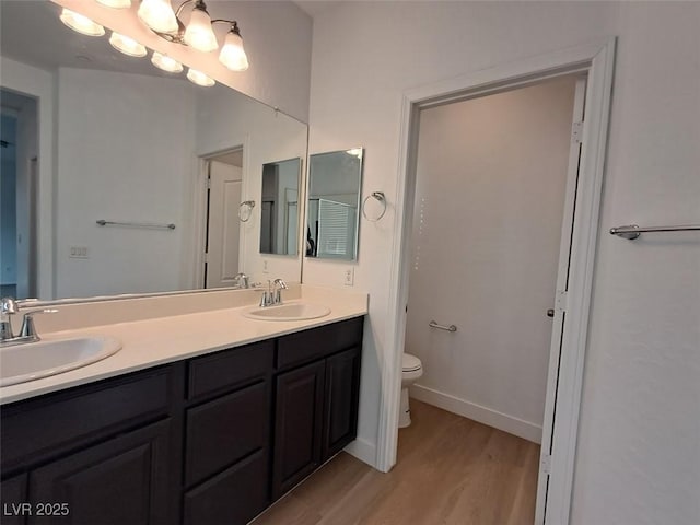 bathroom featuring wood-type flooring, vanity, and toilet