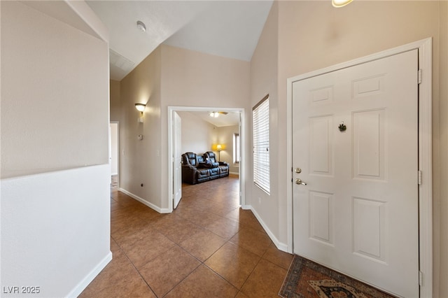 foyer with tile patterned flooring and vaulted ceiling