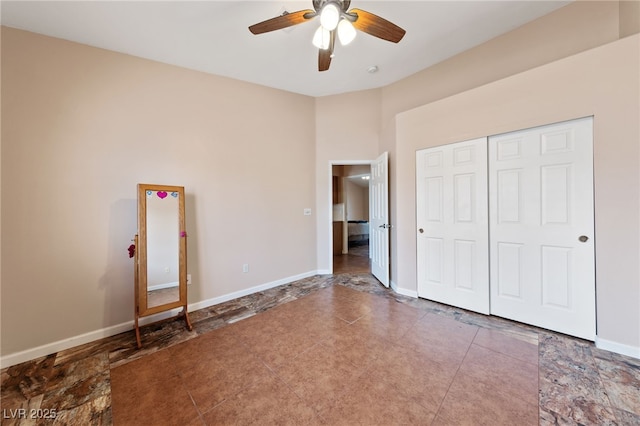 unfurnished bedroom with ceiling fan and a closet