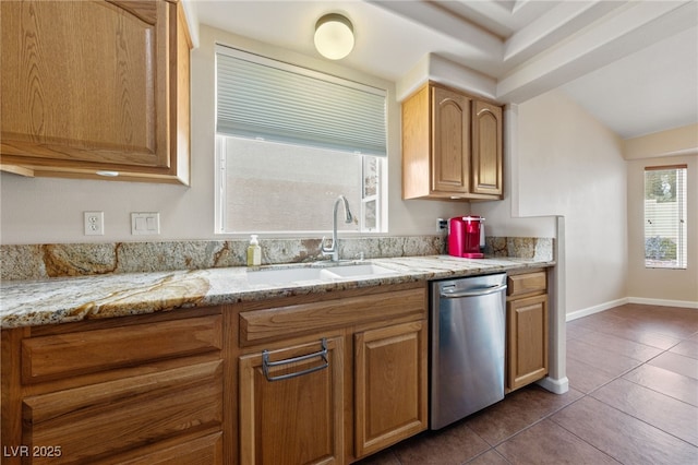 kitchen featuring dishwasher, sink, dark tile patterned flooring, and light stone counters