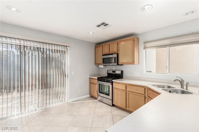 kitchen with stainless steel appliances, sink, and light tile patterned floors