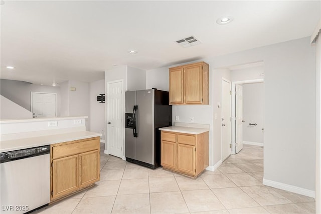 kitchen with stainless steel appliances, light tile patterned floors, and light brown cabinets