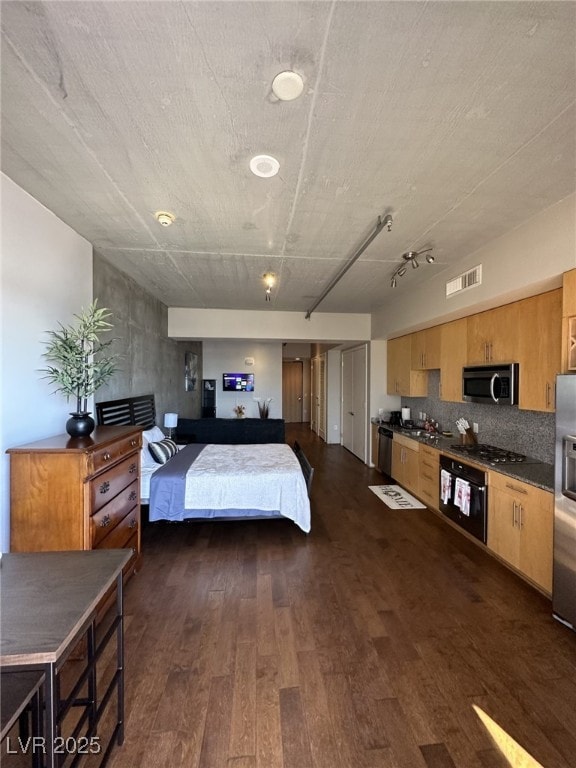 bedroom with dark wood-type flooring and stainless steel refrigerator with ice dispenser