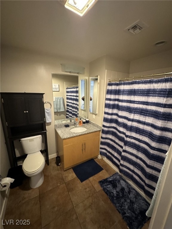 bathroom featuring vanity, tile patterned flooring, and toilet