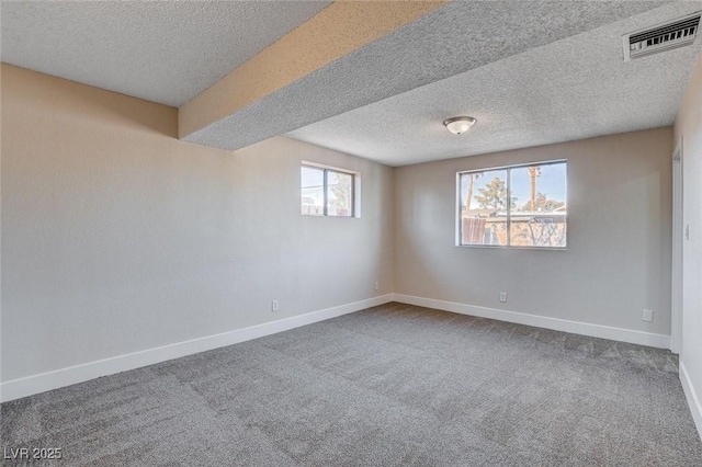 unfurnished room with carpet flooring and a textured ceiling