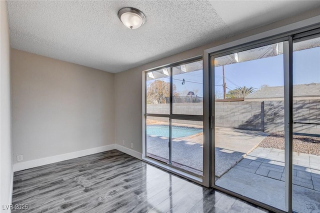 spare room with hardwood / wood-style flooring and a textured ceiling