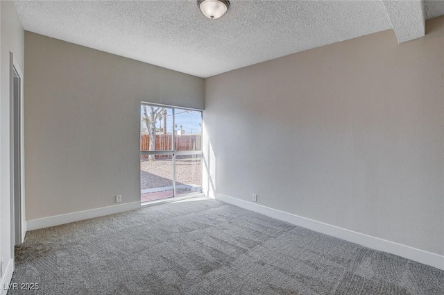 empty room featuring carpet and a textured ceiling