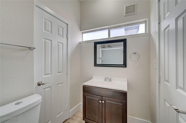 bathroom with hardwood / wood-style flooring, vanity, and toilet