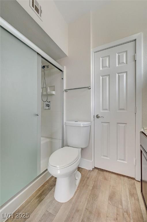 bathroom featuring vanity, an enclosed shower, and toilet