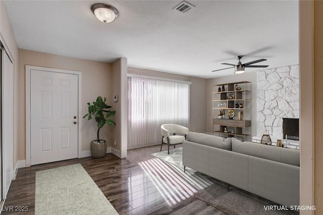 living room featuring ceiling fan and dark hardwood / wood-style flooring