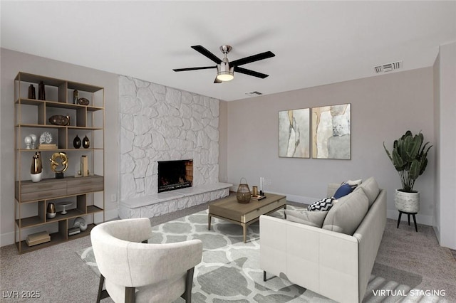 living room featuring ceiling fan, a stone fireplace, and light carpet