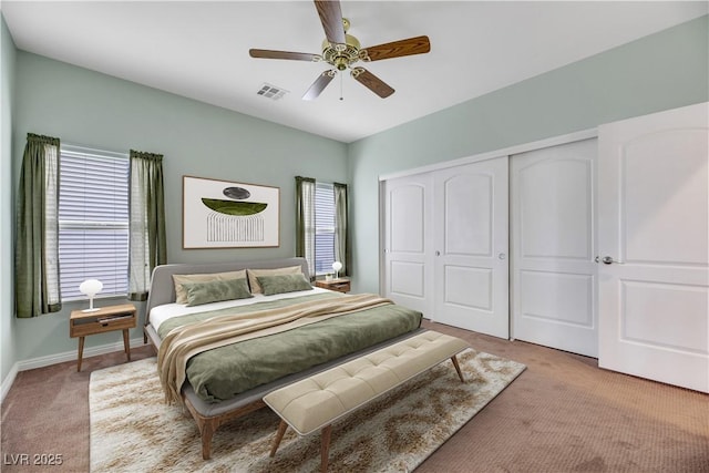 carpeted bedroom with multiple windows, a closet, and ceiling fan