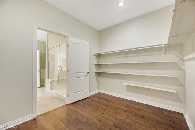 walk in closet with wood-type flooring